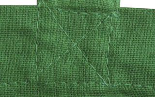 Détail de la couture en croix sur les poignées d'un sac en tissu